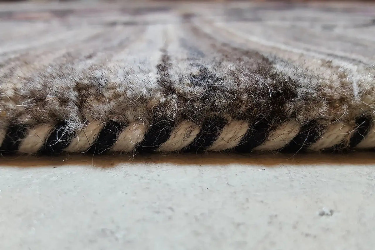 Gabbeh rug edge close-up with dense, multicolored fringes and pile texture