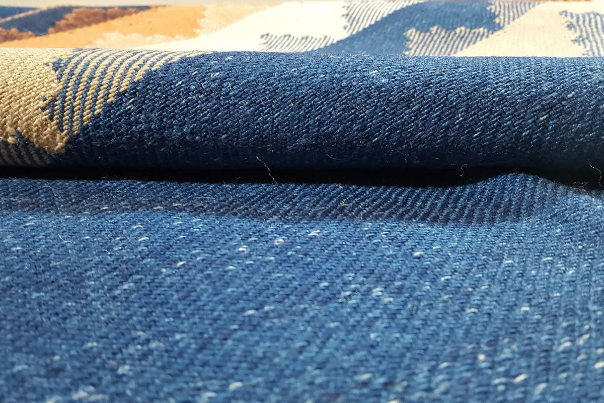 Carpet surface close-up: blue fabric with woven-in stripes in beige and orange