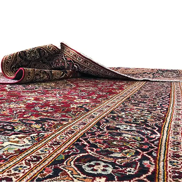 Red Oriental rug with a woven border and multicolored ornamental pattern