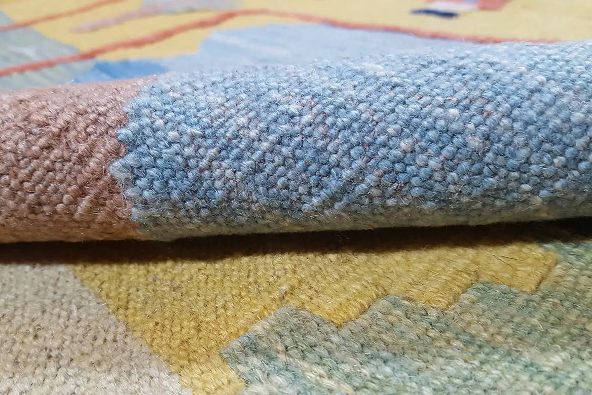 Kilim rug with a visible woven texture at the edge, blue-gray section