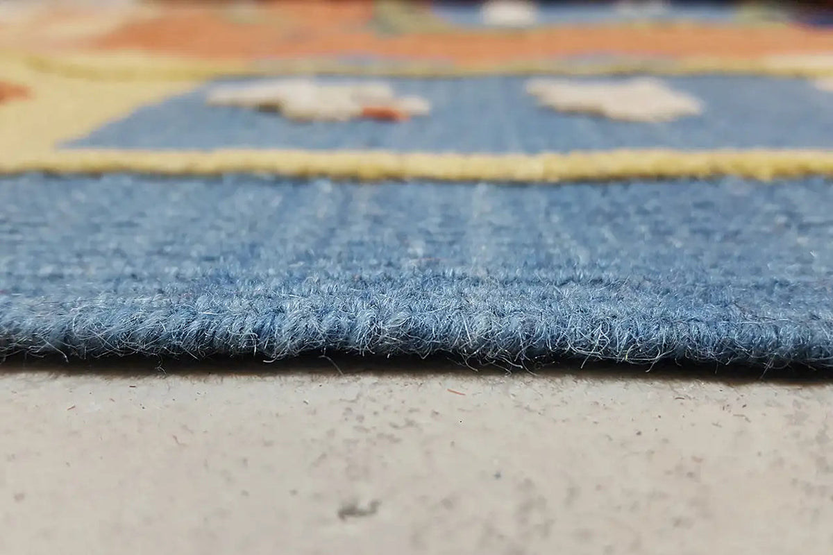 Rug edge with dense pile and dark blue fringe border