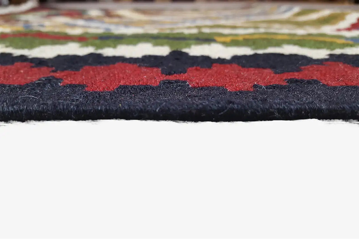 Close-up of fringe trim, dark yarn, and multicolored patterned ribbons