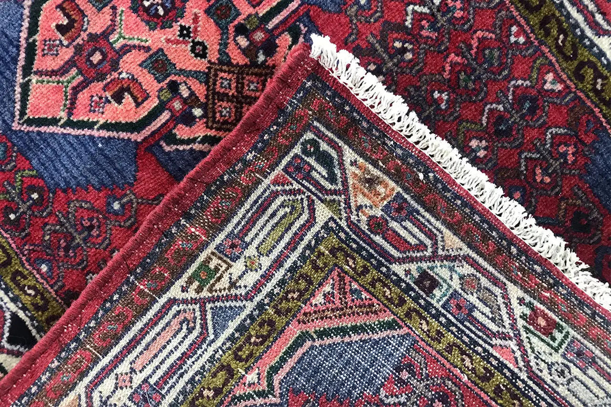 Diagonal rug: dark red pattern, white fringes, and geometric border
