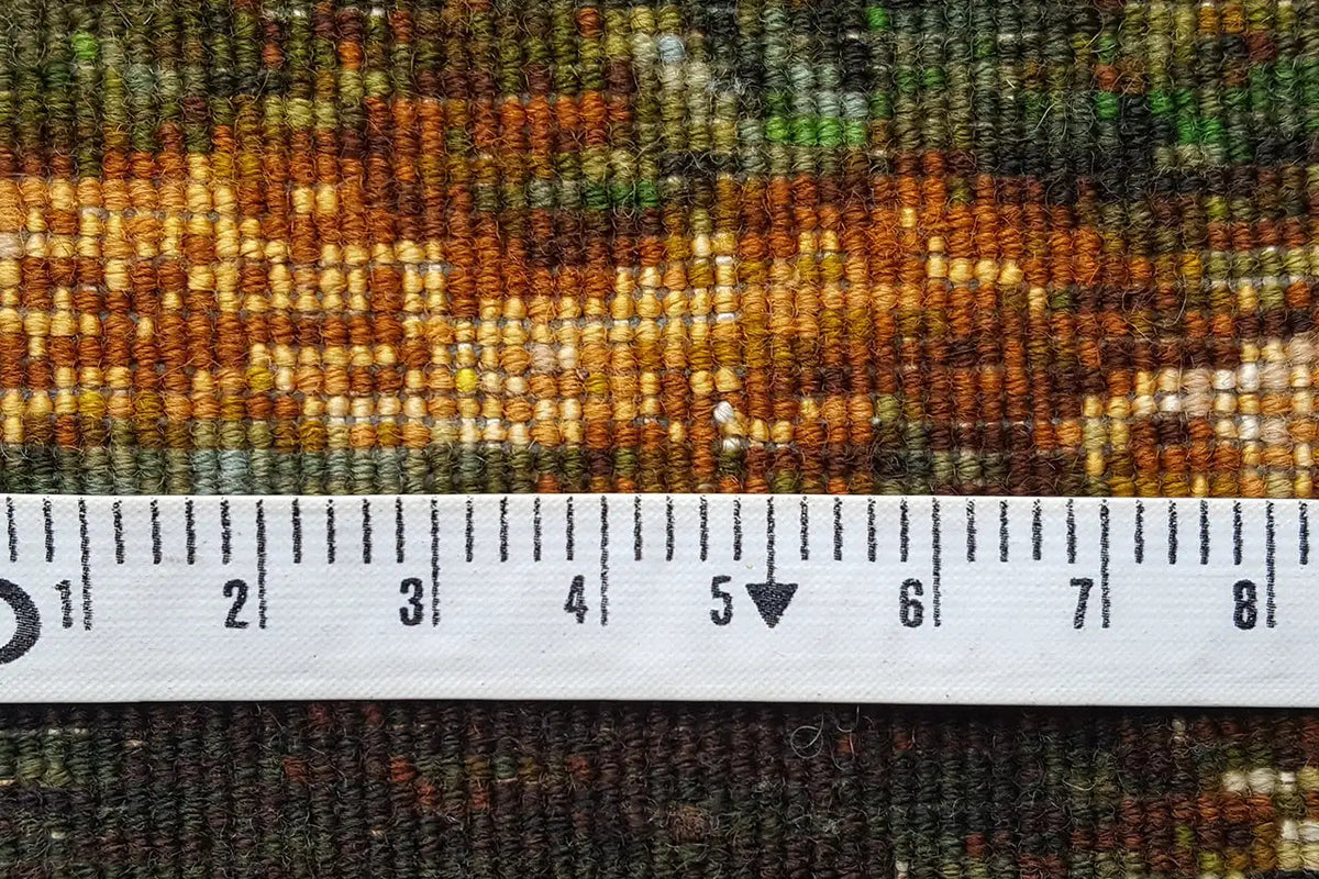 Close-up: woven tapestry with measuring tape, multicolored threads, fringe area