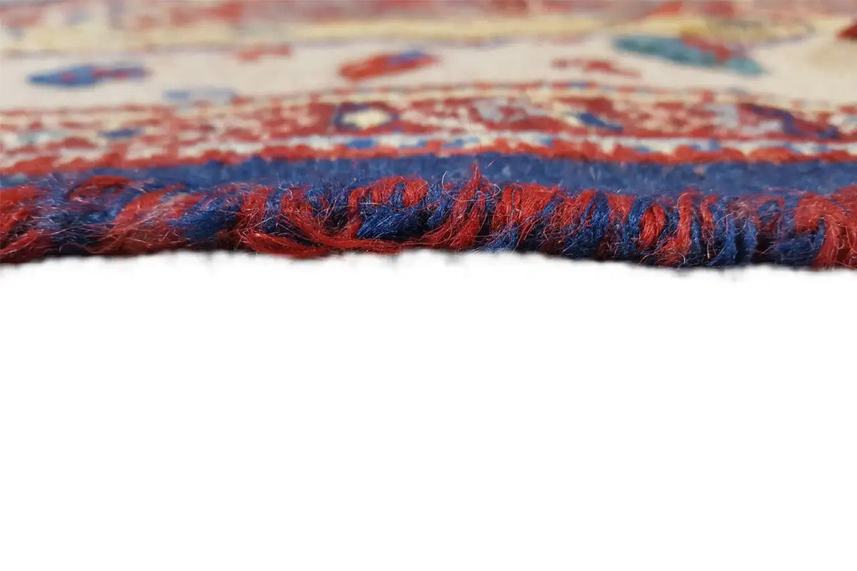 Dark blue carpet fringe along the edge of a colorful patterned Oriental rug