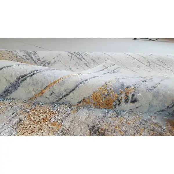 Designer rug with an abstract pattern in light gray, with black and ochre accents