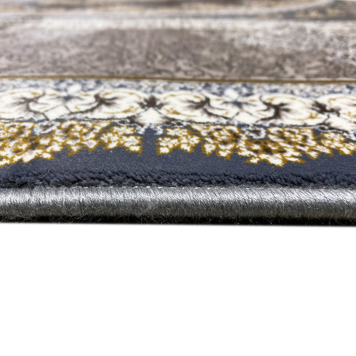 Carpet edge with pile beginning; silver-gold patterned stripes on the dark background, barely visible.