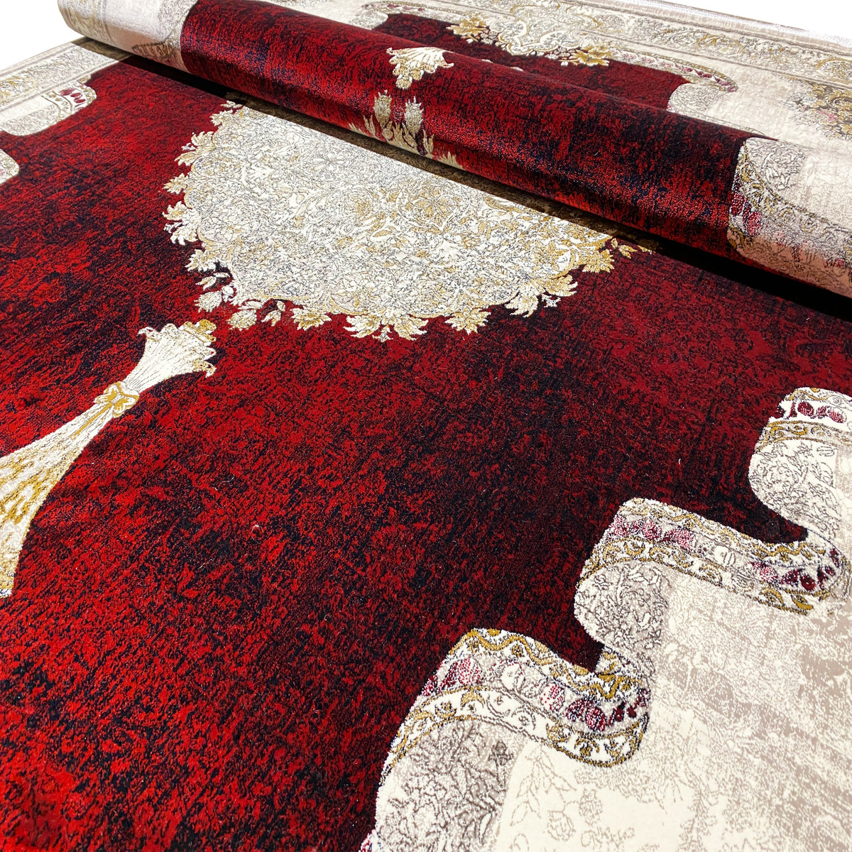 Burgundy-red carpet with woven patterns and silver relief, detail at the edge