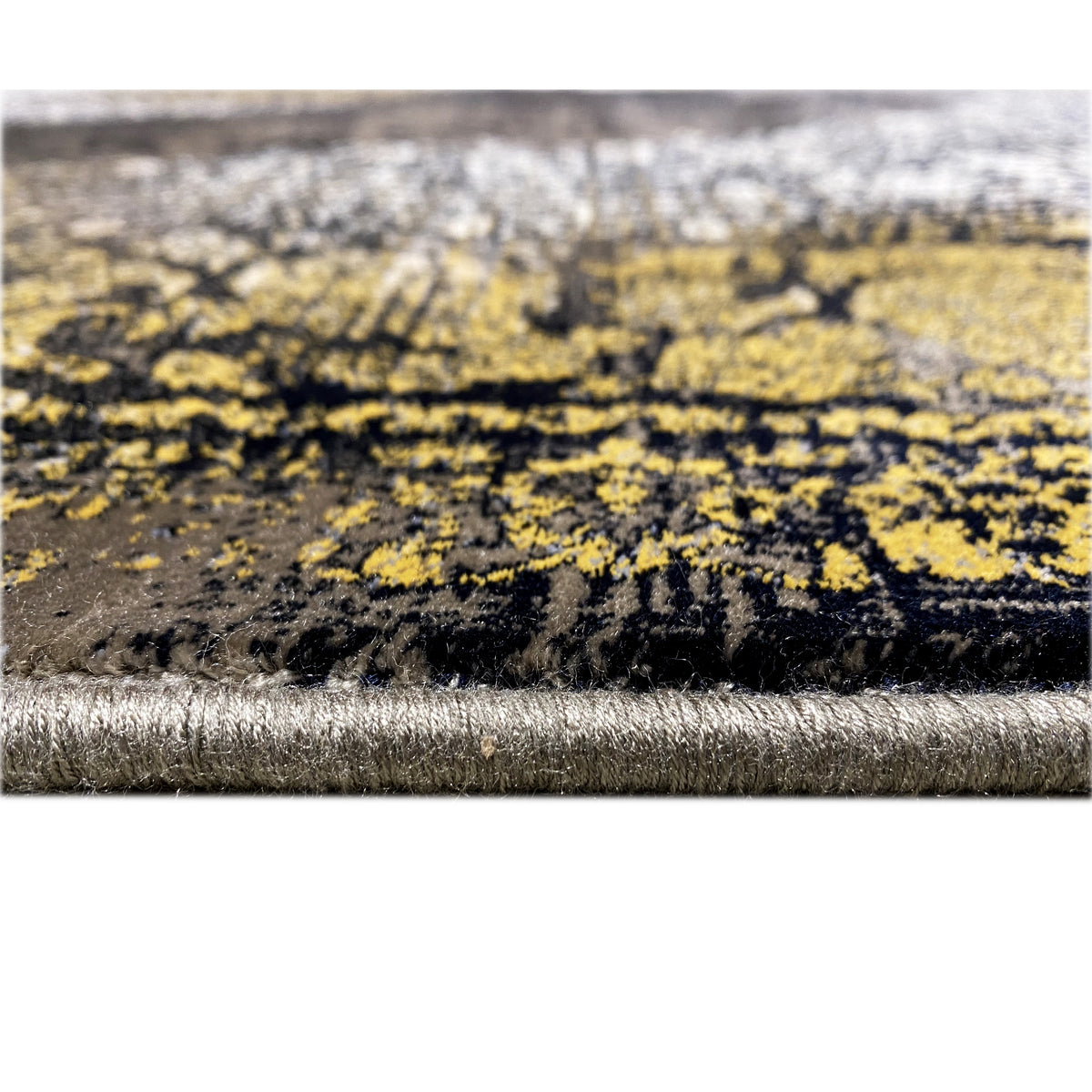 Carpet edge in detail: black pile with a silver border and gold-colored patterned stripes