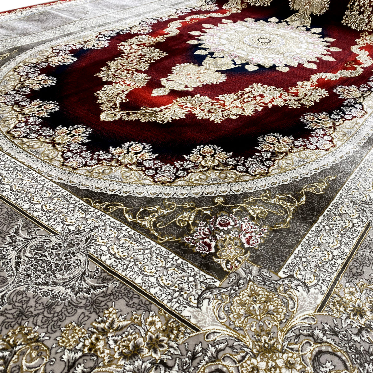 Close-up of a carpet pattern with a red medallion, dark border, and silver ornaments