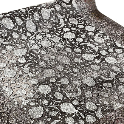 Velour rug with a dense floral ornamental pattern in silver on a dark background