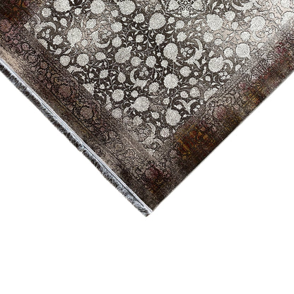 Rug corner with a detailed floral pattern in light beige on dark brown, fringed edges