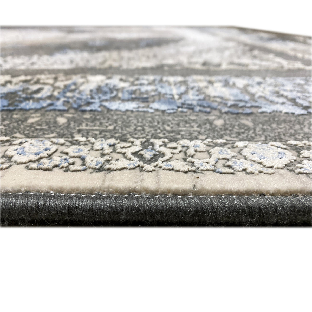 Carpet 170x240 cm close-up of the edge with a blue decorative gradient and textured pile surface