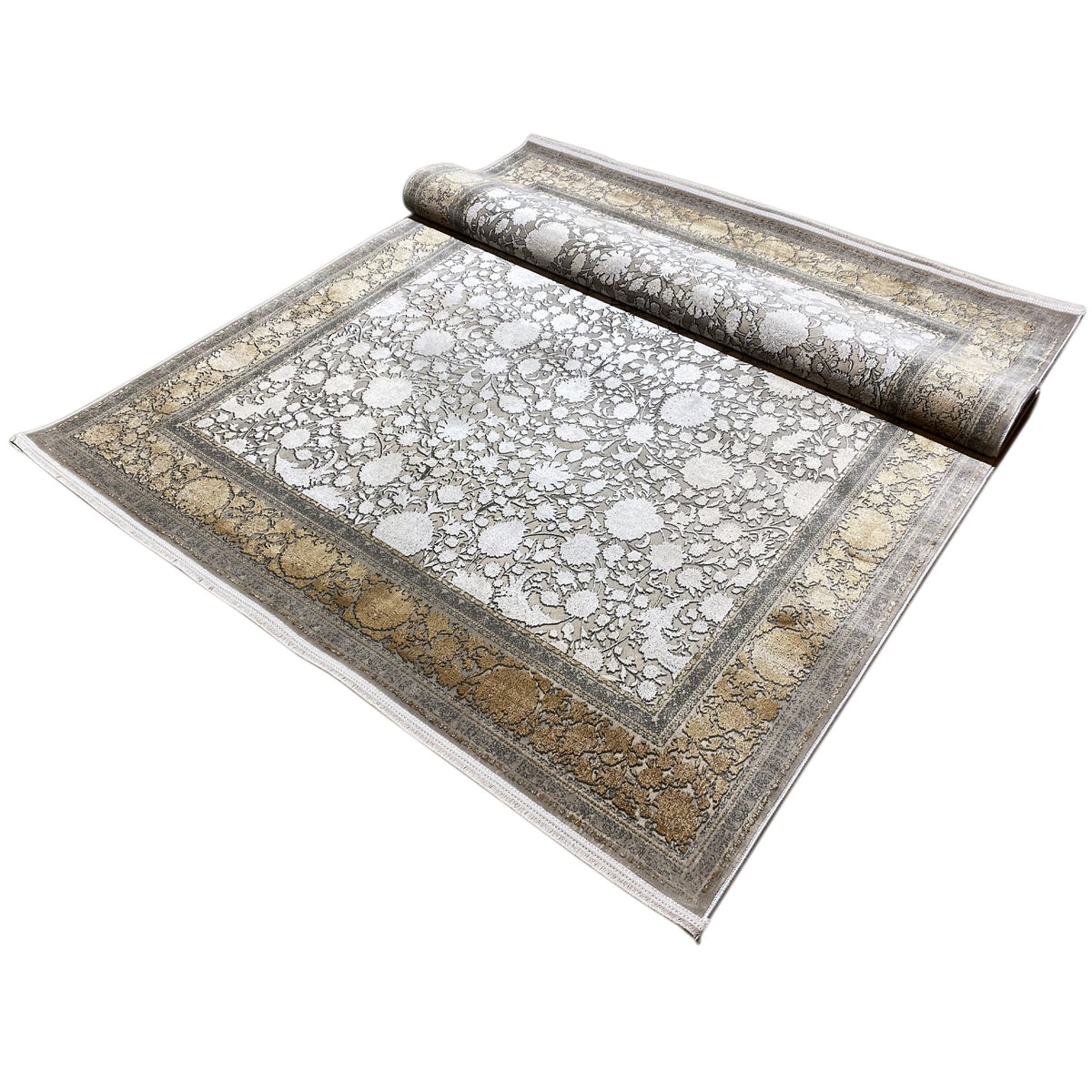 Silver-gold carpet rolled up, floral ornamentation and decorative border visible