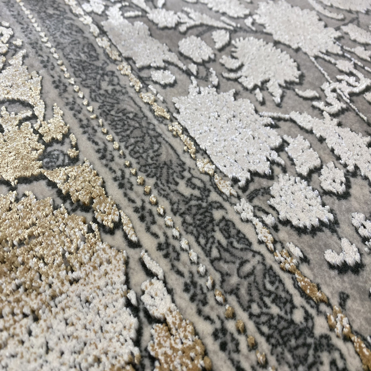 Close-up: silver-gray rug with floral ornaments and gold accents