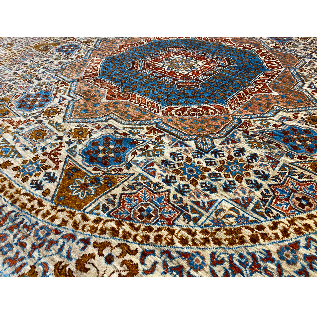 Close-up: rug pattern with a blue medallion and geometric ornaments in beige/brown