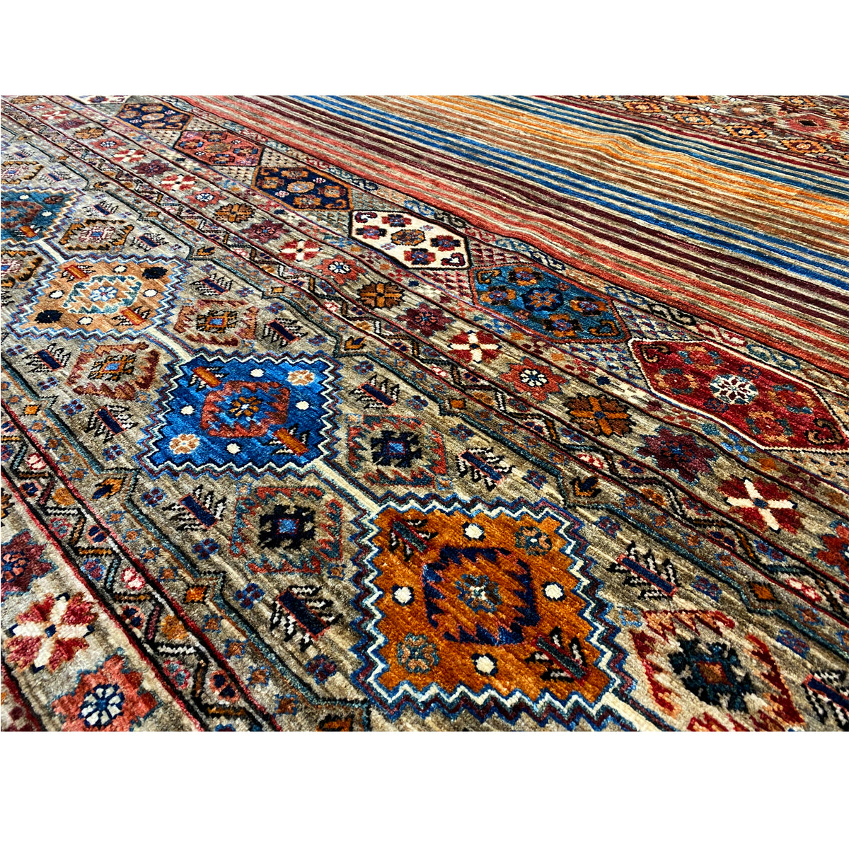 Close-up of the carpet pattern: many small ornaments in blue, orange, red, and beige.