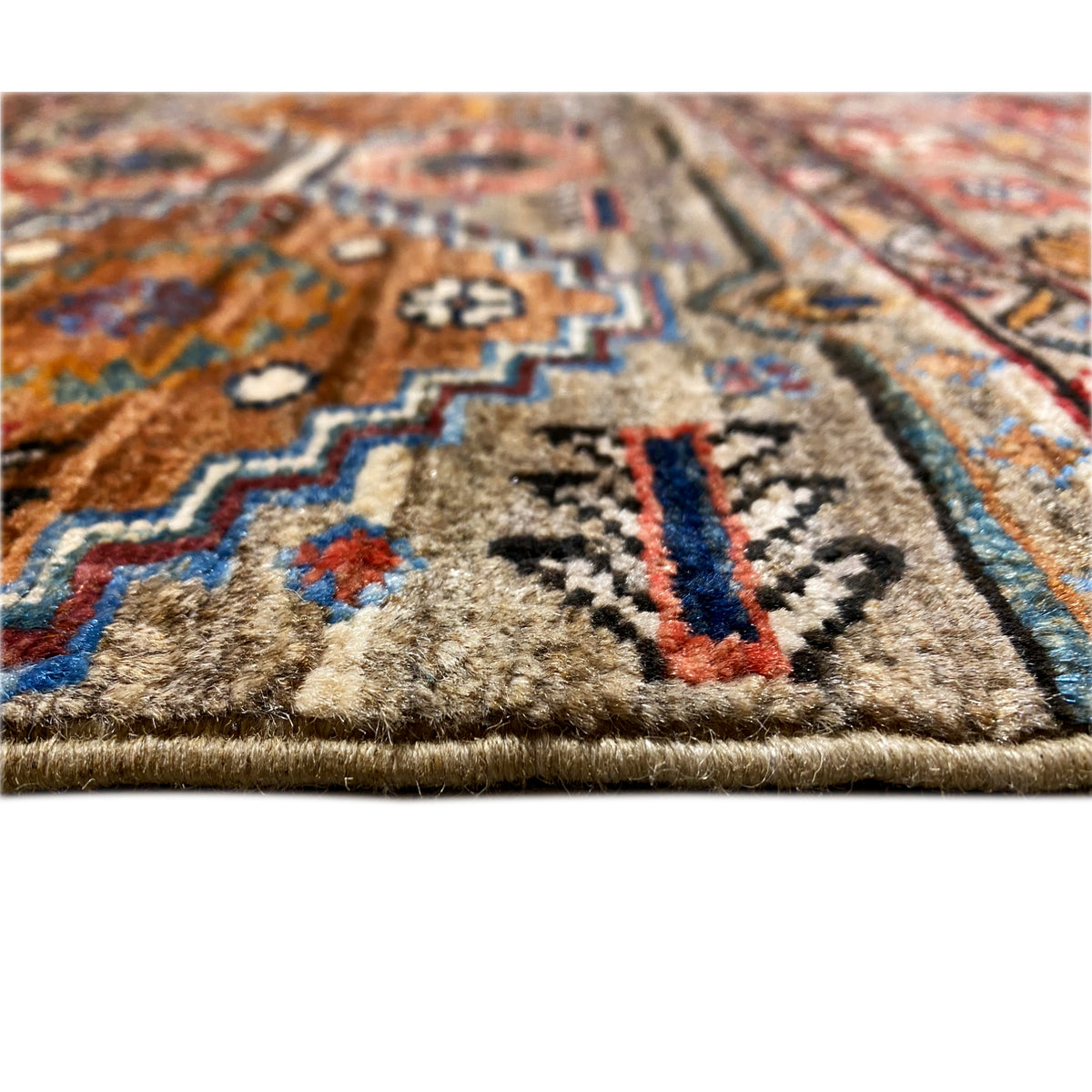 Close-up of the carpet surface with a woven pattern, brown-beige base, and colorful accents.
