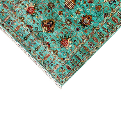 Corner detail of the turquoise Khorjin rug: border ornaments, floral motifs, and edge fringes
