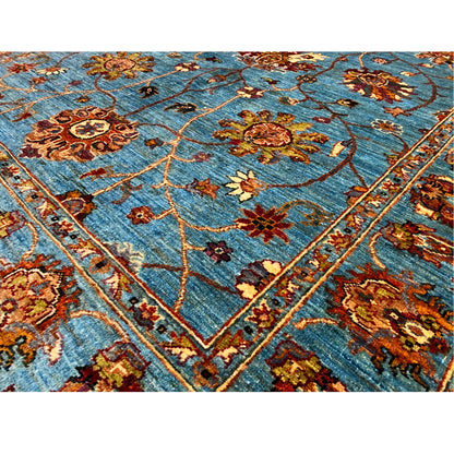 Blue Khorjin rug close-up: floral motifs, vine lines, and decorative border