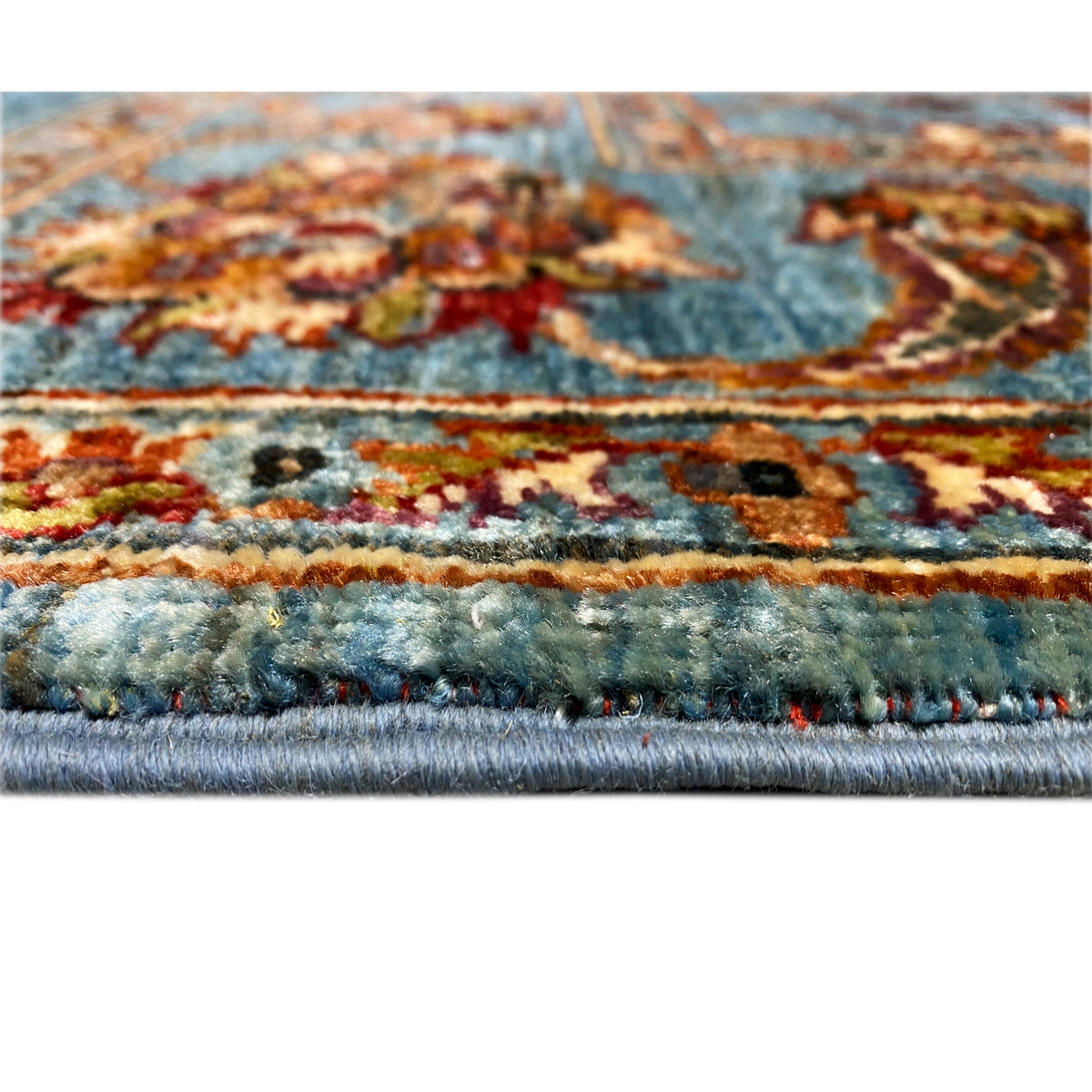 Rug edging with fringe and a dense pile, blue with colorful accents