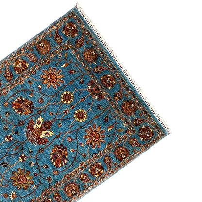 Blue Khorjin rug corner with ornamental border, floral motifs and fringes