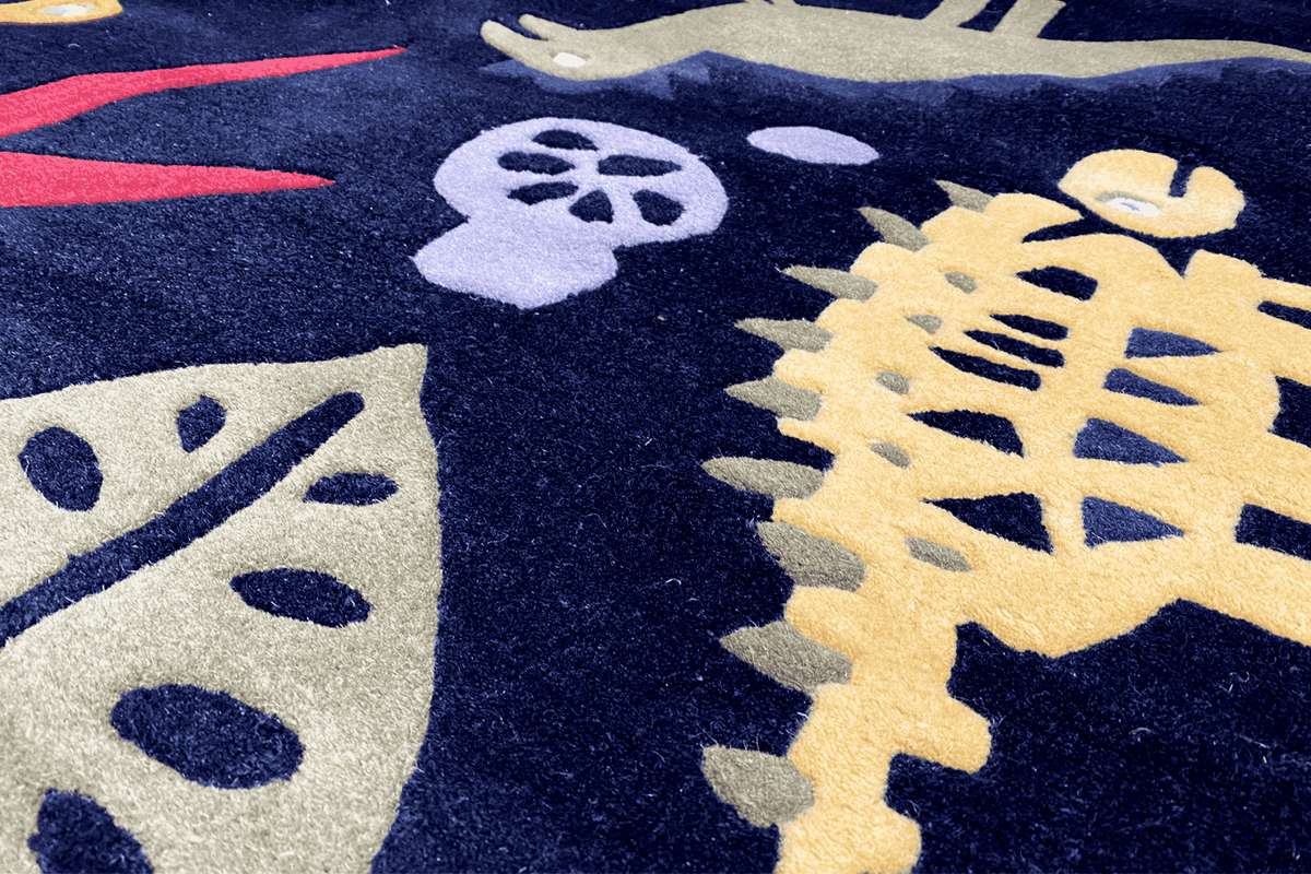 Close-up: colorful dinosaur graphic on a dark blue children's rug