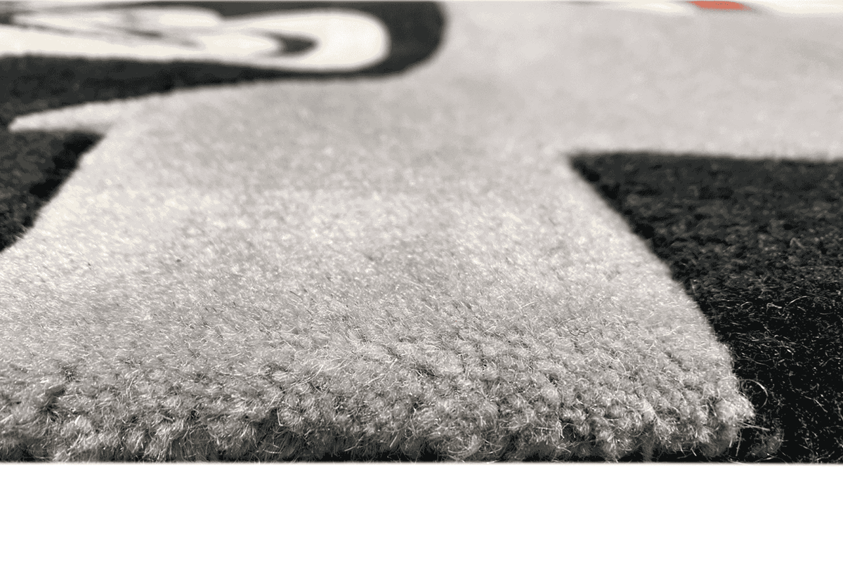 Children's rug, detail of the dense pile in gray with a black patterned area