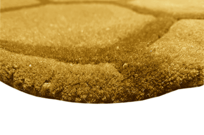 Round honeycomb rug, yellow-brown pile in detail, close-up of the selvedge