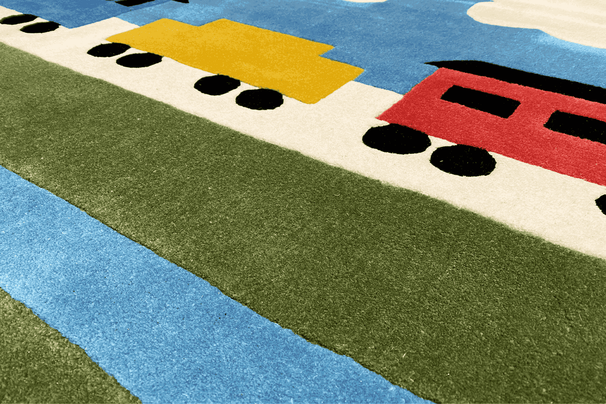 Children's rug detail: green area with blue stripes and train vehicles