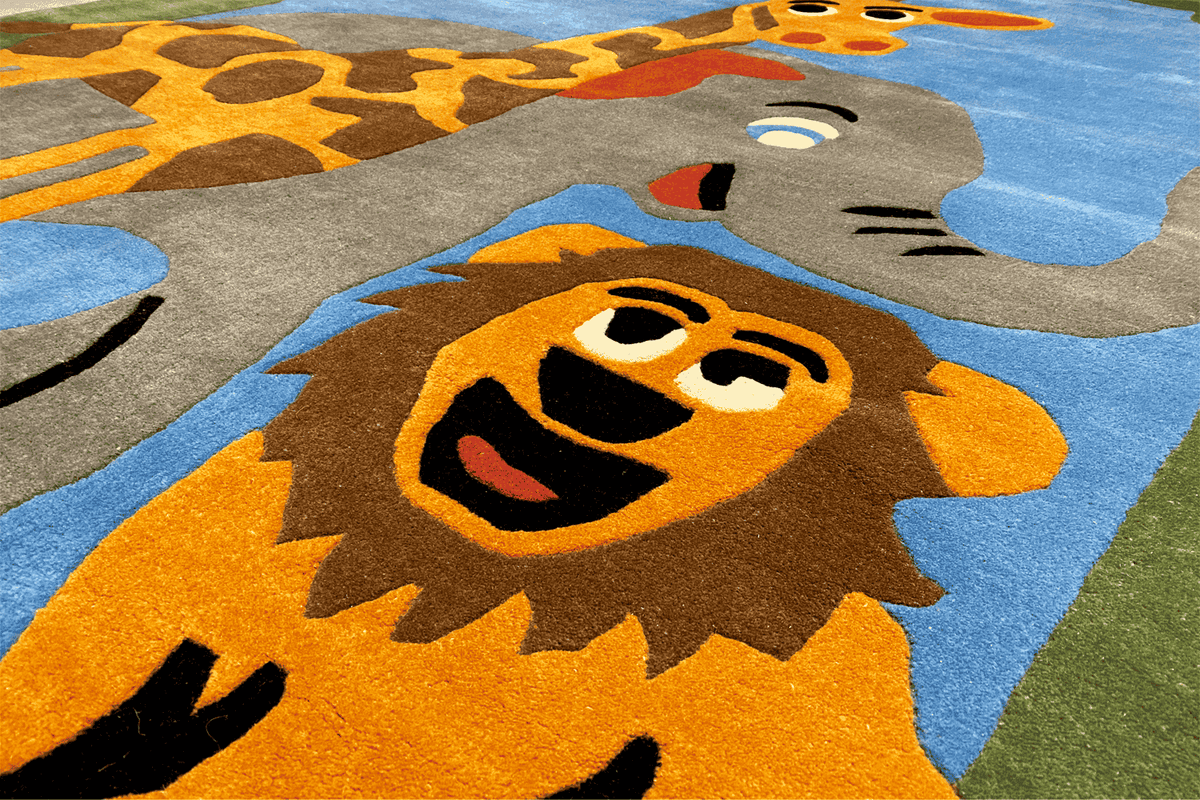 Children's room rug detail: lion's head and elephant motif on a blue background