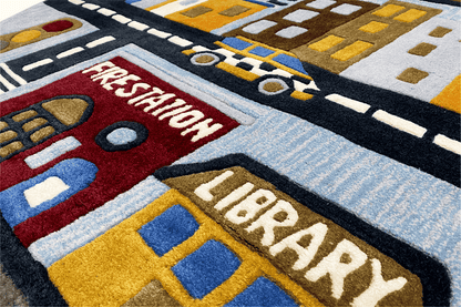 Detail of the children's town rug with “Firestation” and “Library” in the street scene design