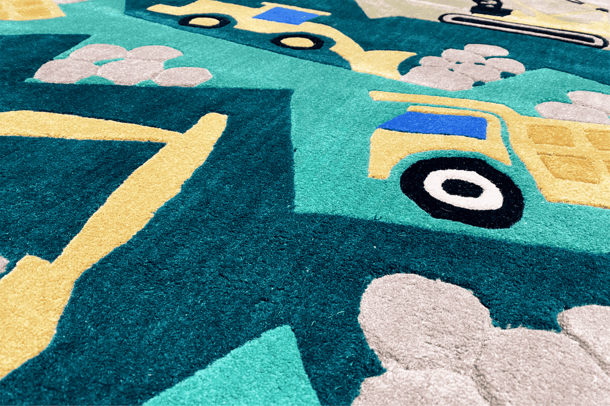 Close-up of a children's excavator play mat: yellow outlines and turquoise vehicle graphics