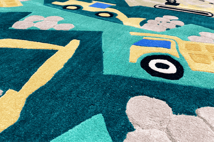 Close-up of a children's excavator play mat: yellow outlines and turquoise vehicle graphics