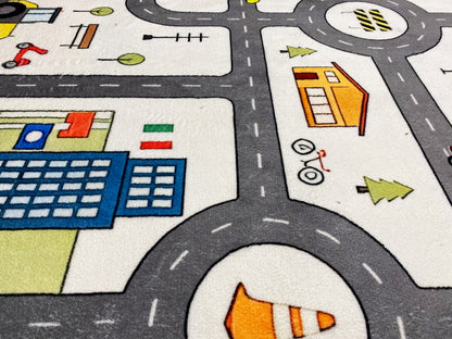 Detailausschnitt Kinderteppich: Kreisverkehr, Straßenmarkierungen und farbige Gebäude/Fahrzeuge.