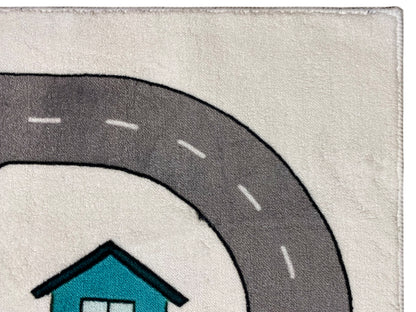 Kinderteppich-Detail: dunkelgraue Straße mit weiß gestrichelten Linien und türkisfarbenem Haus.