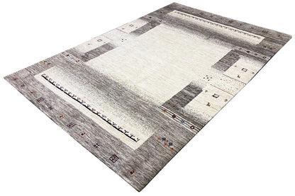 Gabbeh rug at an angle: light center, gray areas, small geometric accents