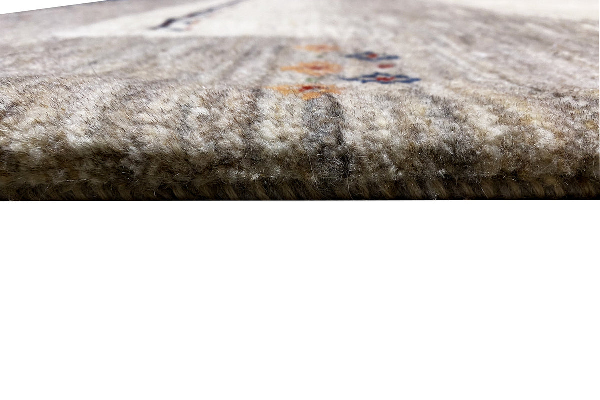 Gabbeh rug close-up of the pile texture, gray-white with fine specks of color