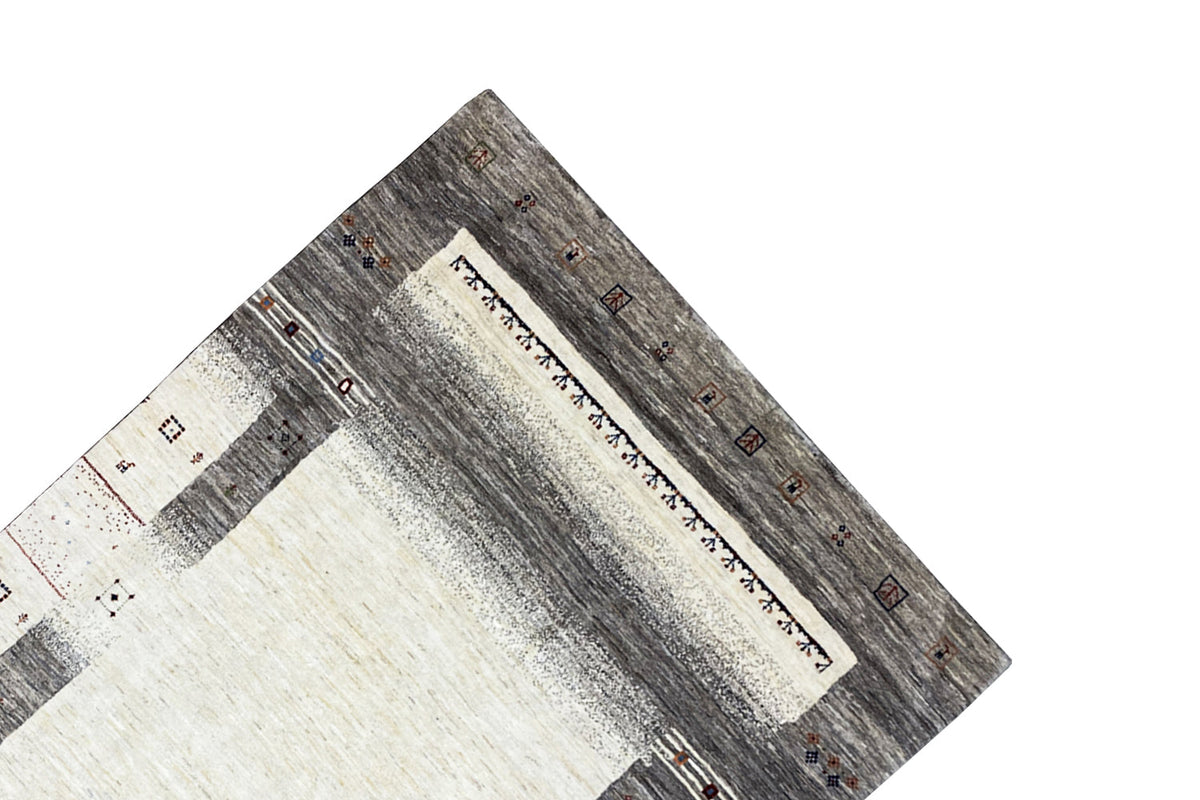 Gabbeh rug close-up: gray borders with a white field and decorative border band along the edge