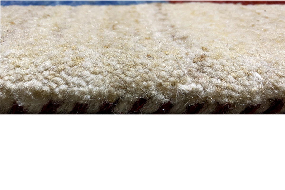 Gabbeh rug: dense, high-pile texture with a beige border and multicolored elements