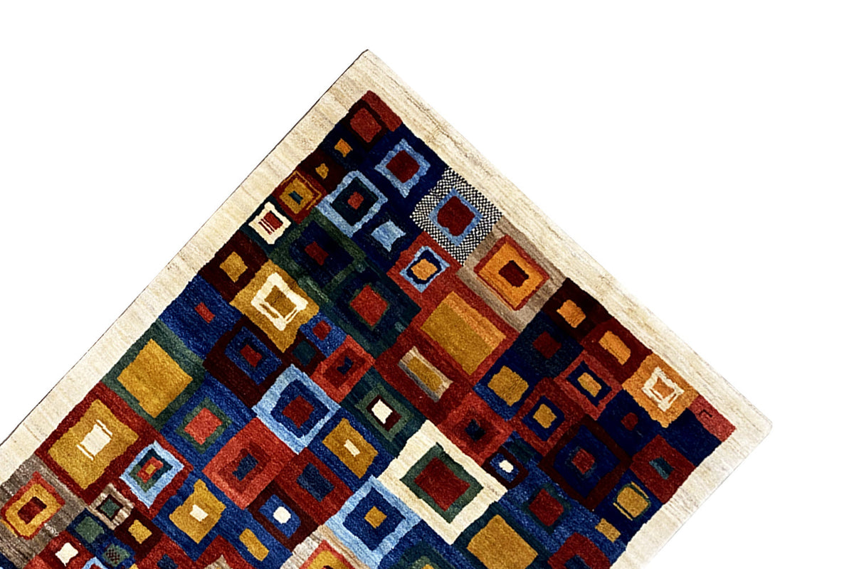 Gabbeh rug corner with geometric squares in blue, green, red, and beige