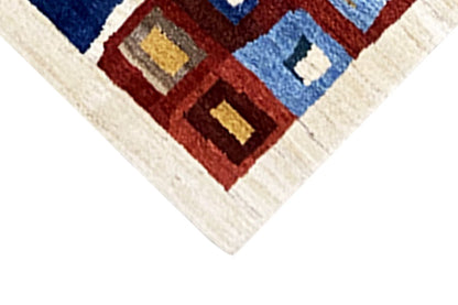 Gabbeh rug corner with a geometric pattern of squares in red, blue, and beige