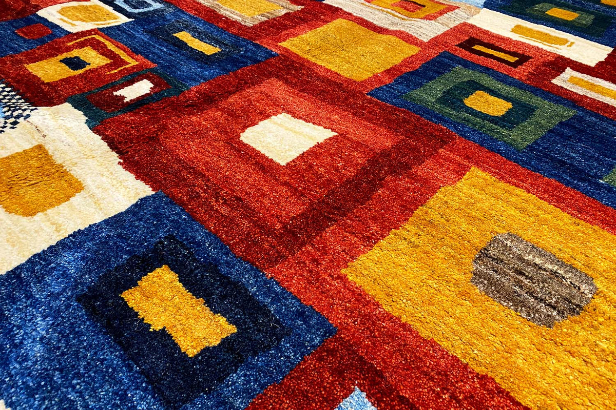 Close-up of a Gabbeh rug: square pattern in red, blue, yellow, and beige