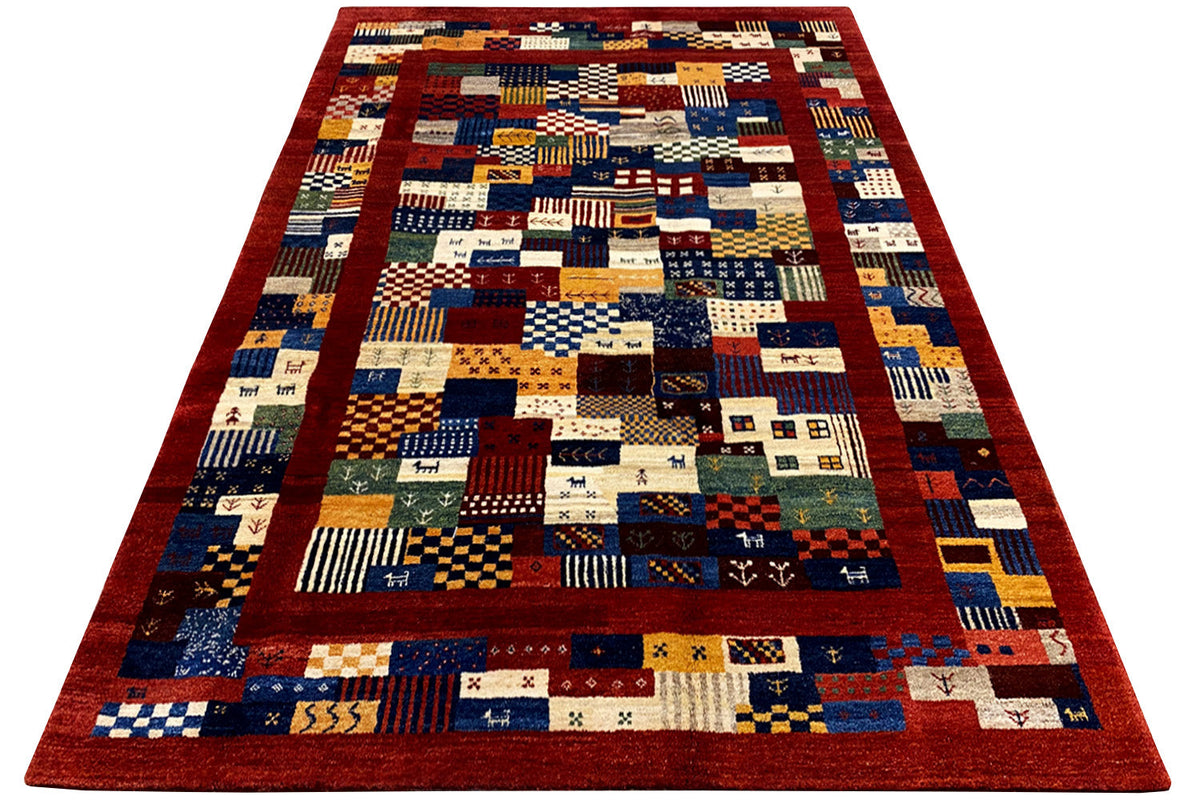 Rectangular rug with geometric patchwork in red, blue, and beige