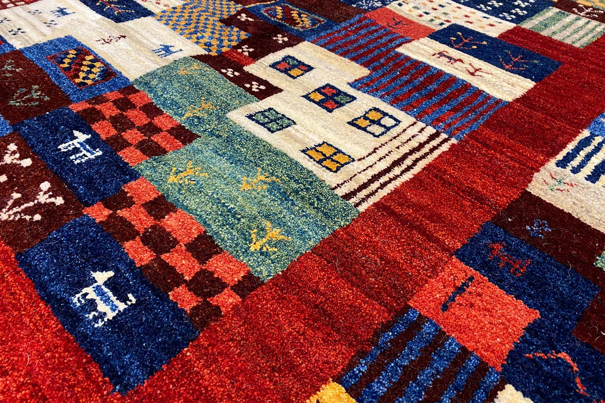 Detailed view of the rug pile with a patchwork design in blue, red, white, yellow, and green