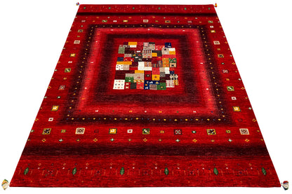 Red Gabbeh rug spread out, with a central patchwork motif and border
