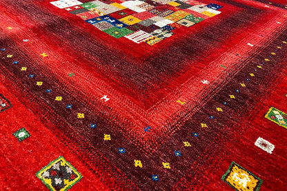 Close-up of a red Gabbeh rug surface with small colorful square motifs