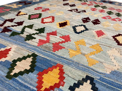 Blue kilim with colorful cross and diamond pattern elements, woven look, close-up view