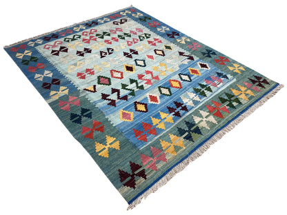 Blue kilim rug with a geometric cross and diamond pattern, fringes along the edge