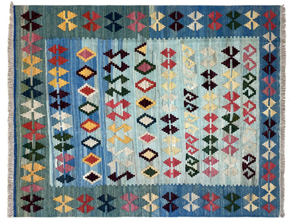 Close-up: blue kilim with a dense diamond, cross, and zigzag pattern, colorful woven texture